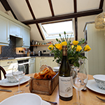 cyllyll a ffyrc a phlatiau ar fwrdd gyda blodau yn y canol