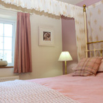 gwely pedwar postyn mewn ystafell wely binc