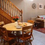 bwrdd bwyd bach crwn yn gegin stabal, wrth y lolfa