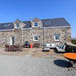 adeilad carreg gyda lle i eistedd tu allan yn yr haul