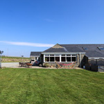 yr adeilad gyda gwair o'i amgylch