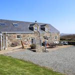 adeilad carreg hardd gyda chadeiriau tu allan